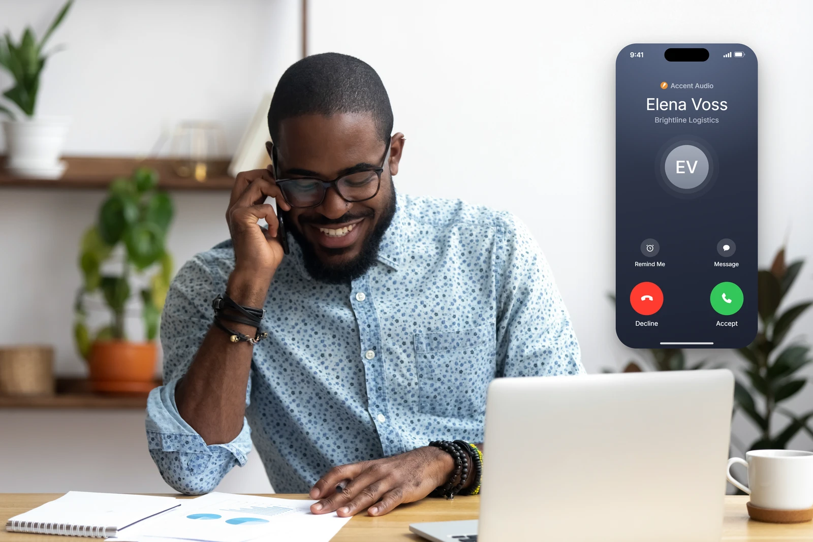 Man at a desk answering a phone next to an inbound call screen