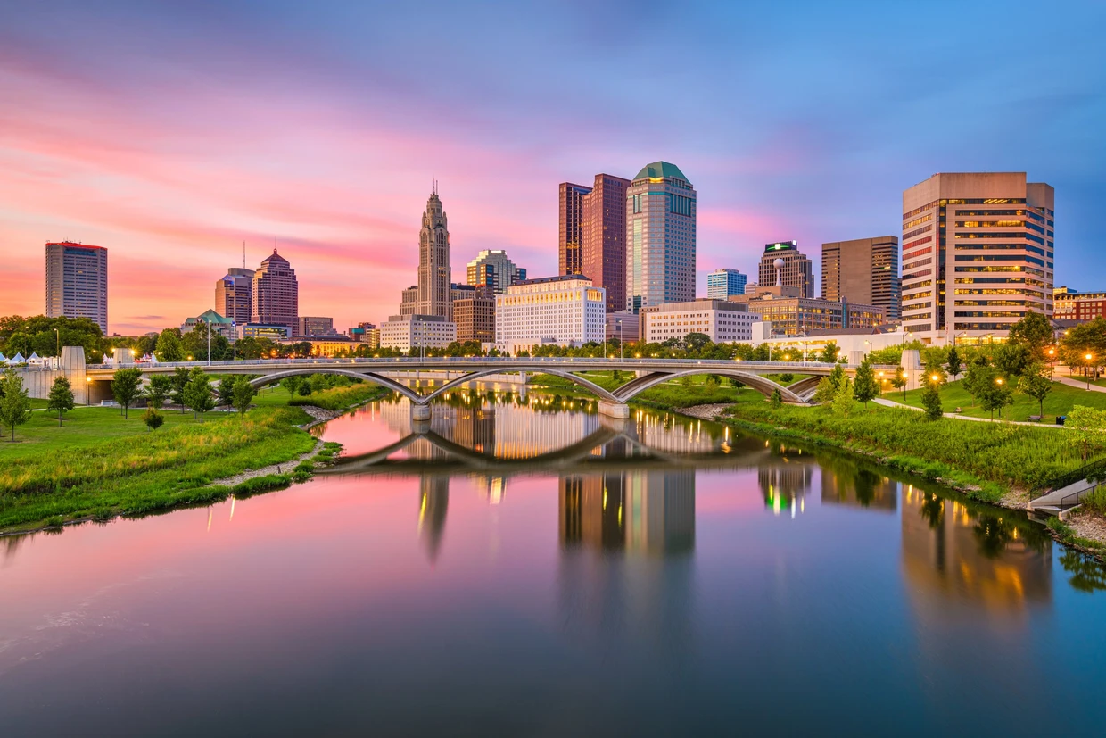 Downtown Columbus skyline at sunset, reflected in the river
